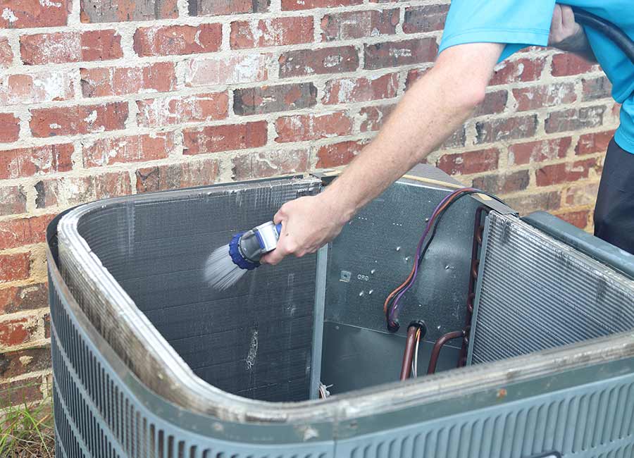 Washing outdoor AC unit interior.